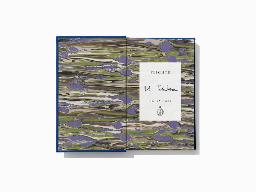 The marbled endpapers of Flights by Olga Tokarczuk, translated by Jennifer Croft. The signed and numbered bookplate is also shown.